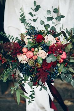 a bridal holding a bouquet of flowers and greenery