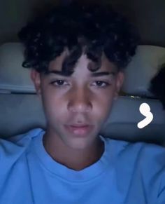 a young boy with curly hair looking at the camera