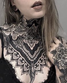 a woman with tattoos on her neck and chest is posing in front of the camera