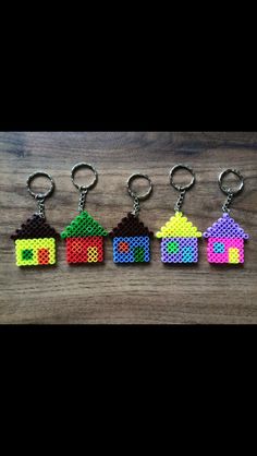 four key chains with small houses made out of perler beads