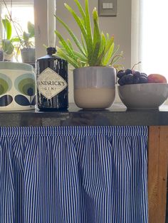 a kitchen counter topped with bowls of fruit and plants