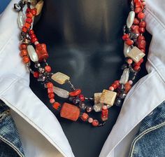 "This is a very unique, one-of-a-kind necklace consisting of several different varieties of red coral, mixed with white and black pearls, fossil ocean jasper and sterling silver beads.   Hand wired on sterling silver  and attached to a large sterling silver hook type clasp, it is very easy to put on and off.   The length is 19\" and it is approximately 2\" wide at its widest point. Truly a one-of-a-kind statement necklace. Perfect gift for an Ocean-loving woman. The silver Manta Ray earrings on Unique Red Coral Gemstone Bead Necklaces, Coral Multi-strand Necklace For Gift, Coral Beaded Multi-strand Necklace, Coral Multi-strand Necklace As Gift, Marine Jewelry, Multi-strand Coral Necklace For Gift, Red Multi-strand Necklaces With Natural Stones, Italian Necklace, Multi-strand Red Coral Beaded Necklaces With Polished Beads