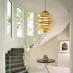 an elegant staircase with glass table and chandelier in modern home interior design style