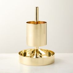 a gold toilet brush holder on a white counter