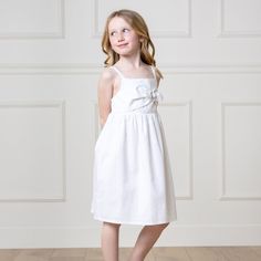 Your girl will be a summer stunner in our flowy sundress, styled with a pretty bow front detail and cut from our soft organic cotton and linen blend. Features adjustable button straps and an elastic bodice for a comfortable fit. Fully lined in organic cotton. A light and fresh look she will love. 55% Linen, 45% Organic Cotton, exclusive of trims. Garment is OCS-Certified. Fully lined in organic cotton. Adjustable button straps. Elastic at the back bodice. Machine washable. Hope & Henry is an Ame Summer Cotton Sundress With Knotted Straps, Cotton Sundress With Knotted Straps, Beach Cotton Dress With Bow, Casual Cotton Dress With Bow Straps, Sleeveless Summer Dress With Bow, Summer Cotton Dress With Bow Tie Back, Spring Beach Dress With Bow Detail, Spring Beach Dress With Bow, Spring Sleeveless Sundress With Bow Tie Back