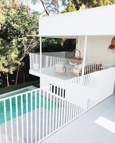 a white house with a pool in the back yard and stairs leading up to it