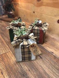 two wrapped presents sitting on top of a wooden table