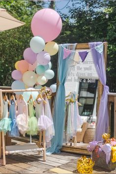 there are many balloons and dresses on display