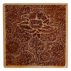 an intricately carved wooden plaque with flowers and leaves on the front, in brown