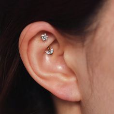 a woman's ear with two small flowers on it