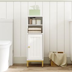 a bathroom with white walls and wooden flooring next to a toilet in the corner