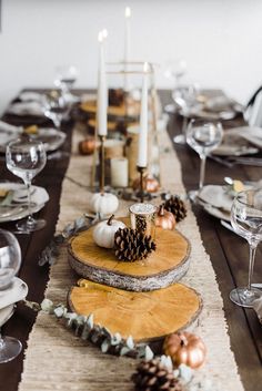 a wooden table topped with plates and candles