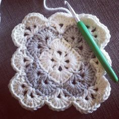 a crocheted doily with a green knitting needle