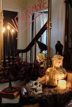 a mirror that is sitting on top of a table next to a skull and candles