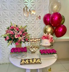 the dessert table is decorated with pink flowers and gold accents, including cupcakes