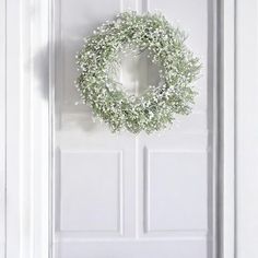 a white door with a wreath hanging on it