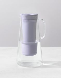 a glass pitcher with a cup in it