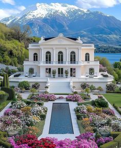 a large white house with lots of flowers around it