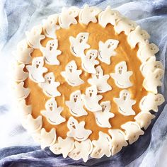 a pumpkin pie with ghost faces on it