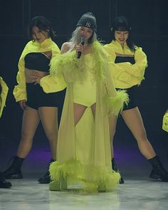 a group of women standing on top of a stage with microphones in their hands