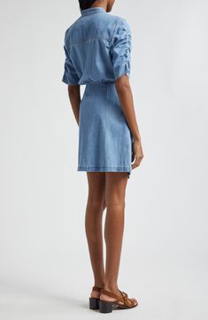 Ruched sleeves and a front tie detail put a contemporary spin on a nonstretch denim shirtdress in a mini length. 33 1/2" length Front snap closure Band collar Elbow-length sleeves Attached waist tie 100% cotton Dry clean Imported Summer Workwear Medium Wash Shirt Dress, Spring Mini Length Denim Dress For Workwear, Relaxed Fit Mini Denim Dress For Work, Spring Mini Shirt Dress With Tie Waist, Knee-length Medium Wash Mini Dress For Work, Chic Short Sleeve Denim Dress For Daywear, Summer Workwear Denim Mini Dress, Summer Denim Mini Dress For Work, Knee-length Mini Dress For Work