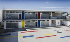 a person walking in front of a multi - colored building