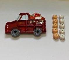 a red toy truck with pumpkins next to it