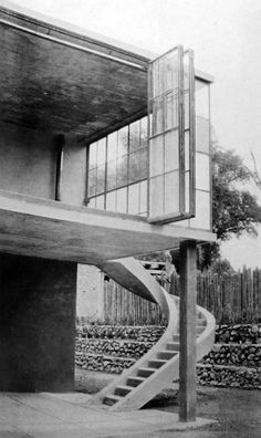 an old black and white photo of a building with stairs leading up to the roof