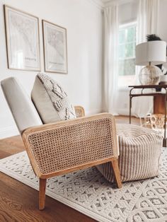 a chair and ottoman in a living room with pictures on the wall behind it,