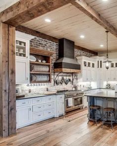 a large kitchen with white cabinets and wood flooring on the walls is pictured in this image