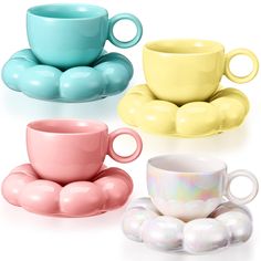 four different colored coffee cups and saucers