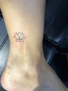 a woman's foot with a small lotus tattoo on the side of her ankle