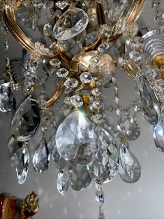 a chandelier hanging from the ceiling with lots of crystal beads on it's sides