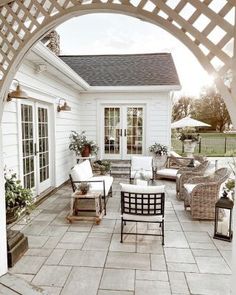 an outdoor patio with chairs, tables and potted plants