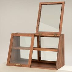 a wooden shelf with two glass shelves on each side and a mirror in the middle