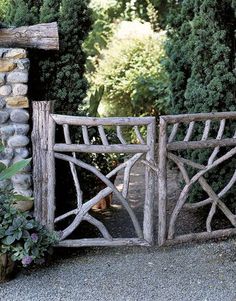 a stone and wood gate in front of some trees