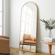 a mirror sitting on top of a wooden floor next to a chair