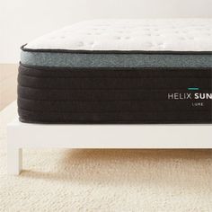 the helix sun mattress is on top of a white bed frame in a room