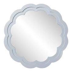 a round mirror with a scalloped edge