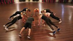 a group of women doing push ups in a gym