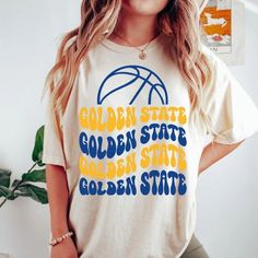 Comfort Colors Golden State Basketball Shirt, Golden State Basketball Sweatshirt, Vintage Style Golden State Basketball shirt -Please check Color and Size Charts before placing the order. You can find them in the listing's photos (Depending on what device you are viewing this listing colors may vary slightly). -Returns and exchanges are accepted only if there are defects "No Extra Costs" We create custom t-shirts with great designs for everyone's liking. If you don't find the size or color you w Golden State Outfit Women, Game Day Yellow Graphic Print Tops, Yellow College Top For Team Spirit, Yellow School Spirit Graphic Print Top, Yellow Graphic Print Top For Game Day, Yellow Graphic Print Top For School Spirit, Yellow Tops With Letter Print For Sports Events, Casual Yellow Tops For Game Day, Collegiate Yellow Tops With Letter Print