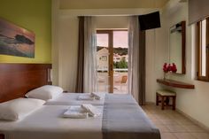 two beds with towels on them in a hotel room