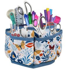 a blue and white flowered purse with scissors, pens, markers, pencils and other office supplies in it