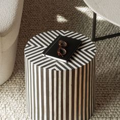 a black and white striped box sitting on top of a table next to a chair