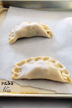 two uncooked dumplings sitting on top of a baking sheet