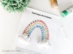 a coloring book with an image of a rainbow and paintbrushes next to it