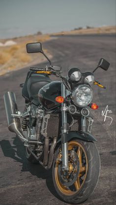 a motorcycle parked on the side of a road next to an empty parking lot with no people