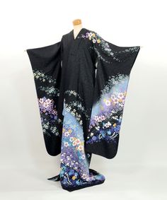 This furisode kimono is a stunning piece made entirely of 100% silk.  The black fabric is woven with shimmering gold threads, adding an elegant sparkle reminiscent of a starry night sky.  The soft blue gradient dyeing adds a gentle touch to the overall design.  This kimono is beautifully adorned with a variety of floral patterns created through traditional yuzen dyeing techniques. There are no noticeable stains, and it is still in a wearable condition.  Whether you choose to wear it or display i Black Silk Evening Kimono, Black Silk Dress With Kimono Sleeves, Traditional Black Kimono With Floral Print, Traditional Black Floral Print Kimono, Traditional Black Dress With Kimono Sleeves, Black Fitted Long Kimono, Fitted Long Black Kimono, Vintage Black Kimono For Spring, Black Silk Kimono For Spring