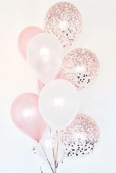 pink and white balloons in a vase with some glitter on the balloon stems, against a white background