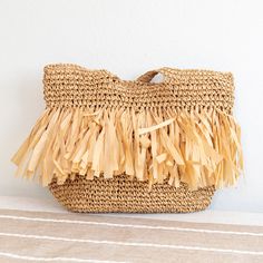 In Stock Now Shipping From Los Angeles The Elena Handbags Large Straw Woven Tote Bag with Tassles is an exquisite accessory ideal for adding a bit of timeless elegance to any occasion. The intricate weaving of the straw provides a stunning textural contrast and the lovely tassels add a touch of sophistication, making it perfect for formal or casual events. Crafted with the utmost attention to detail and quality, this bag is sure to be a treasured favorite for many seasons to come. Please note th Summer Fringe Rectangular Bag, Summer Rectangular Fringe Bags, Summer Fringe Rectangular Bags, Chic Straw Bag With Tassels, Beige Tassel Bag For Beach, Vacation Fringe Tote Bag, Beige Tassel Beach Bag, Beige Tassel Bag For The Beach, Chic Summer Bags With Fringe